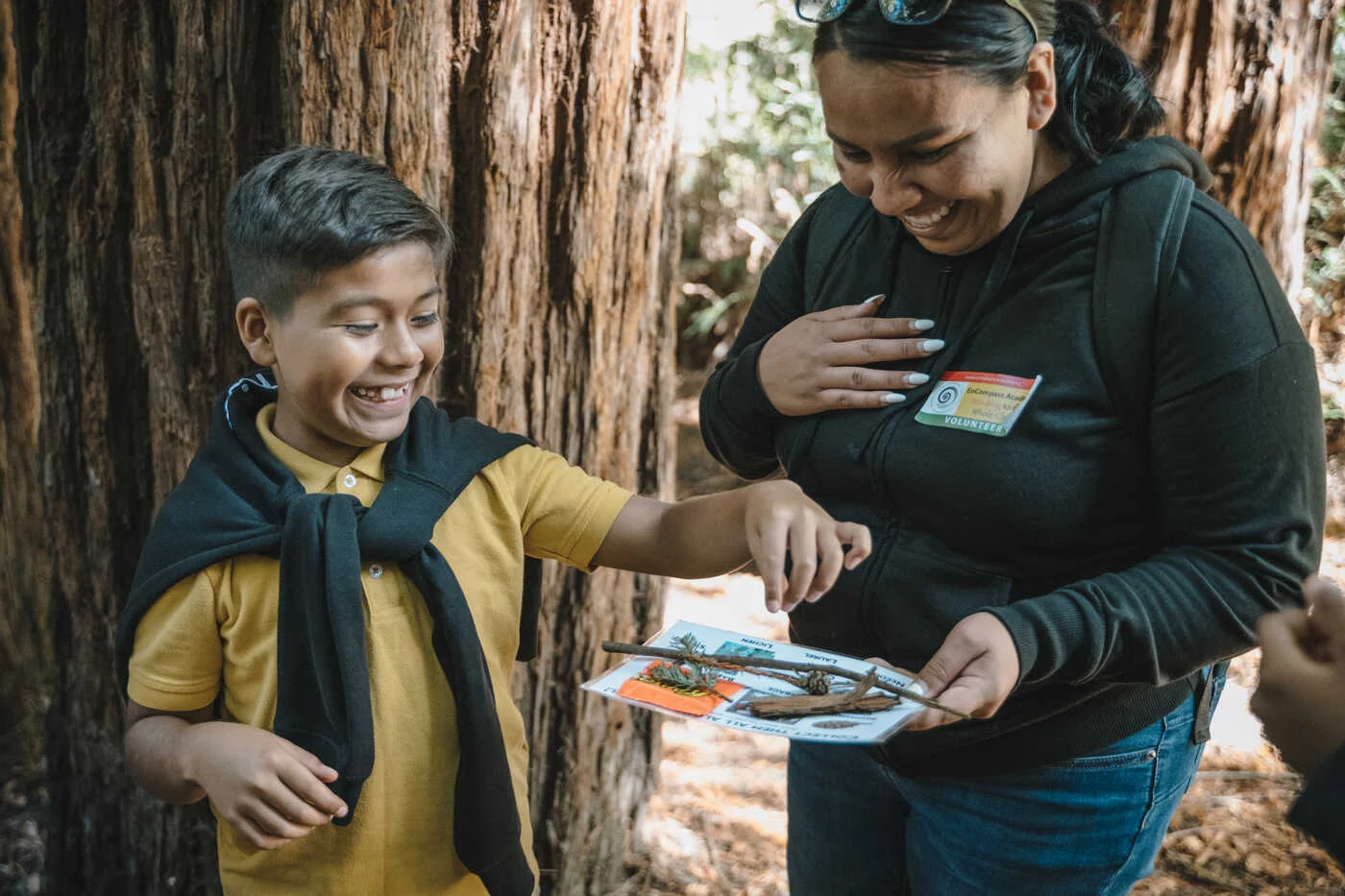 Boy with adult volunteer showing redwood nature activity sheet