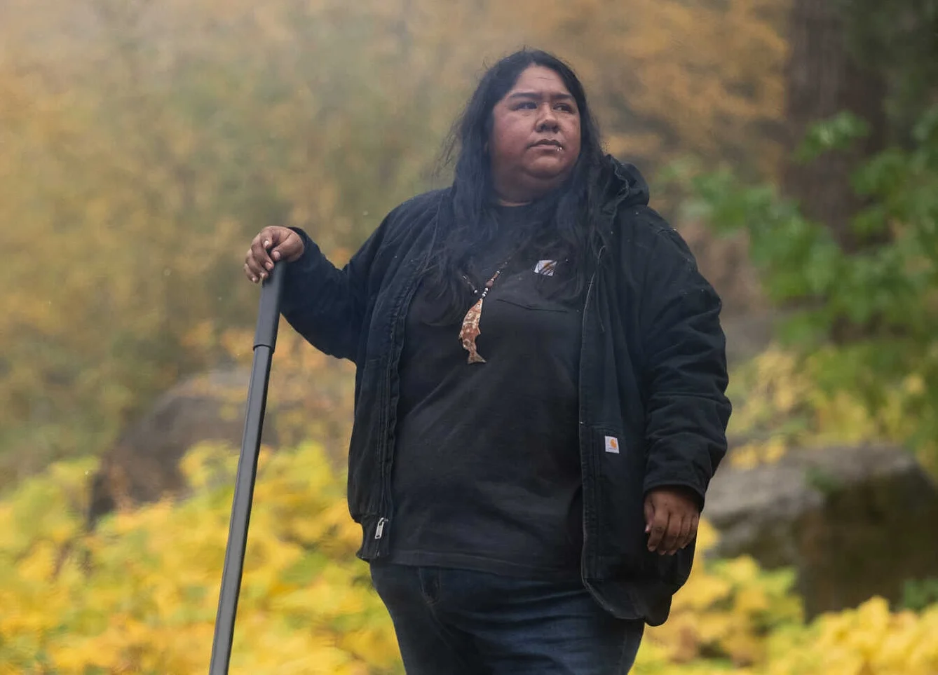 Person standing with shovel monitoring a cultural burn.