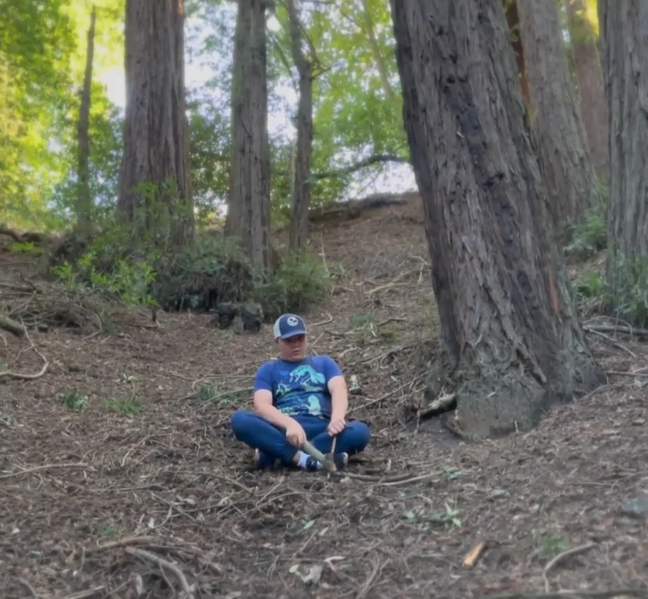 autistic boy plays in the redwood forest