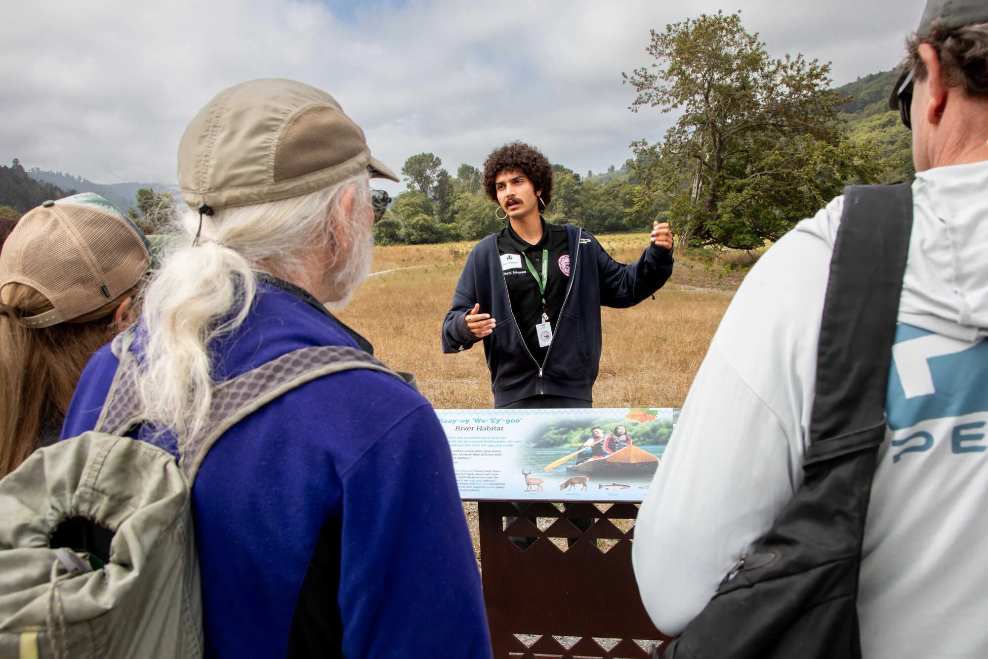 Indigenous man from the Yurok Tribe in a dark hoodie leading a tour