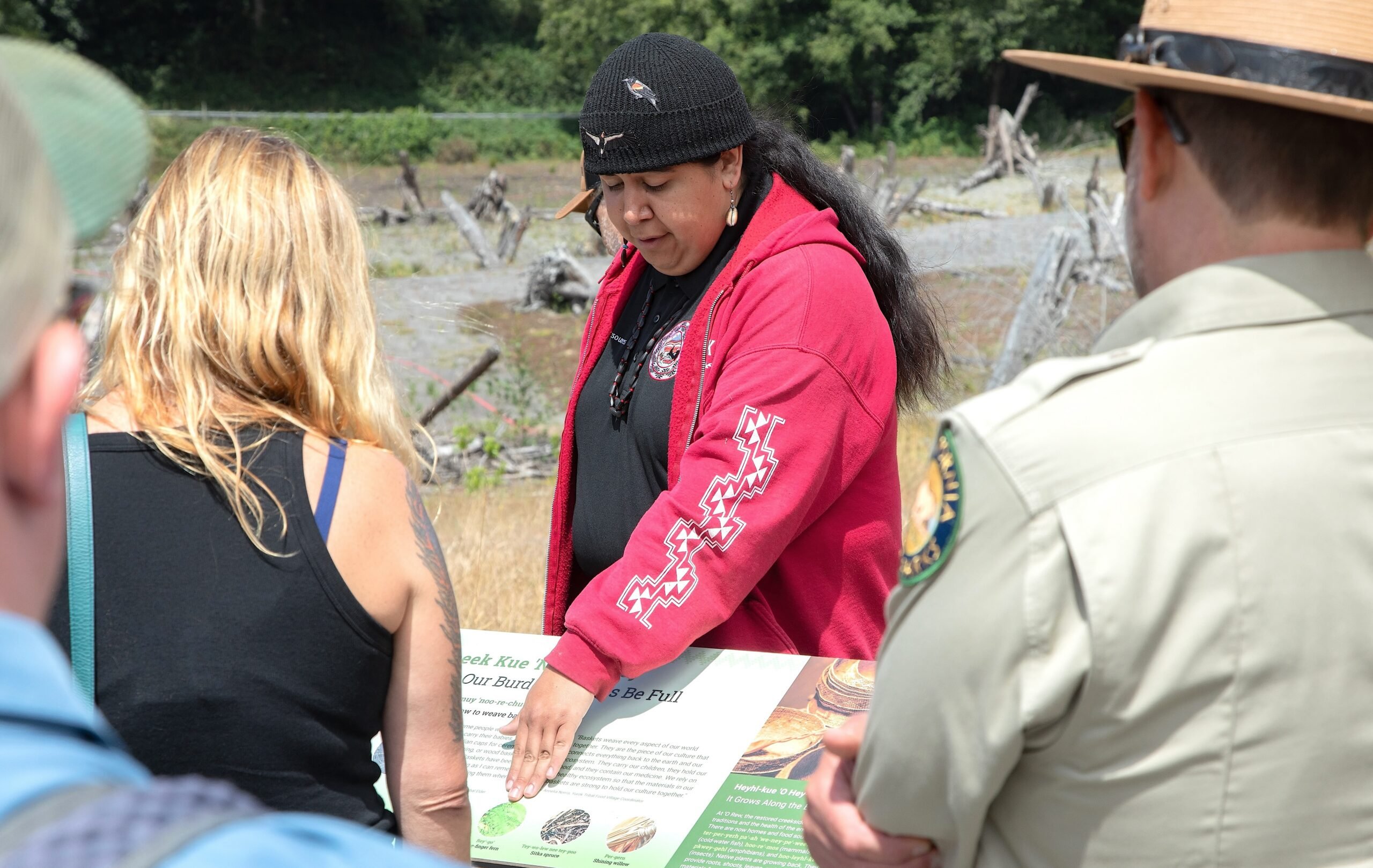 An interpreter with the Yurok Tribe describes the content of an interactive sign to listeners