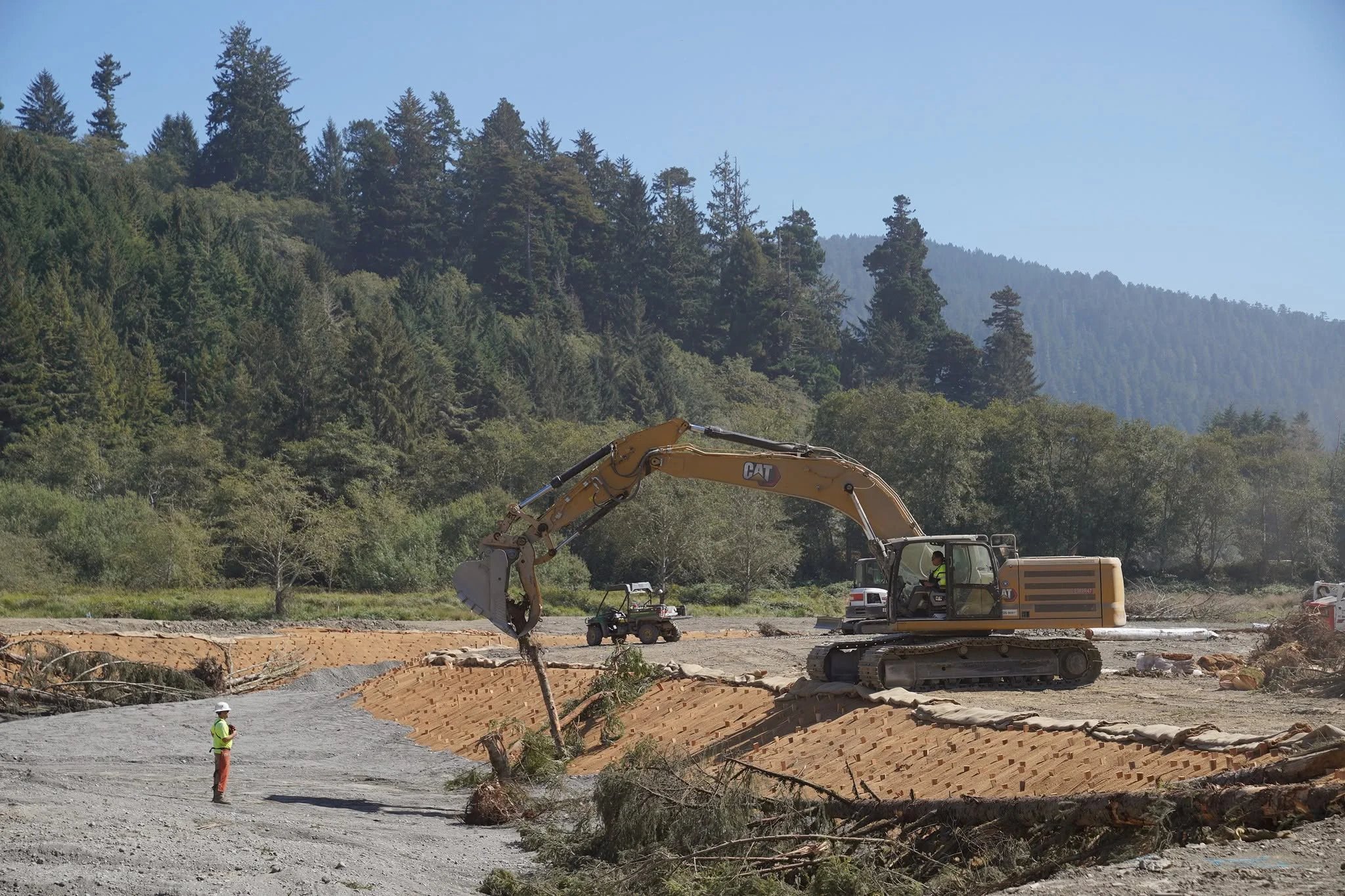 Heavy machinery placing woody debris in the creekside