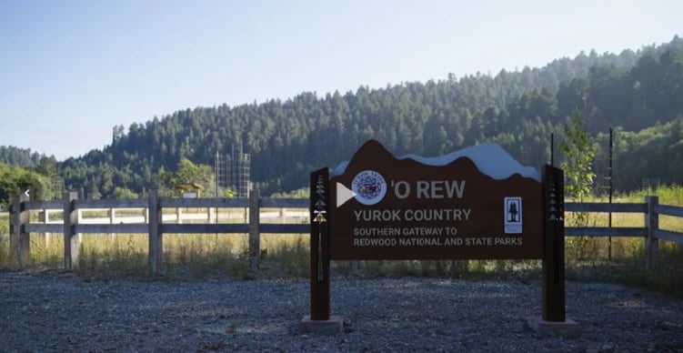 Signage to the park with the Yurok Tribe Logo that reads 'O Rew Yurok Country Southern Gateway to Redwood National and State Parks.